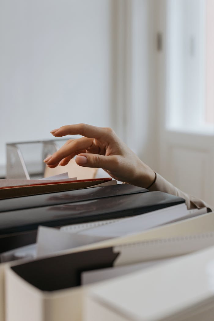 The Art of Drawing Readers In: Your attractive post title goes here Close-up of a hand reaching into a file drawer in an office, signifying organization and archiving.